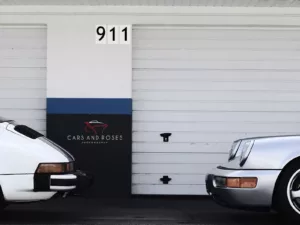 Foto Plexi Porsche 911 Cuadro en metacrilato Porsche 911 vista delantera y trasera simultánea con número 911 marcado entre puertas de garaje, fotografía artística conceptual del icónico deportivo alemán edición limitada