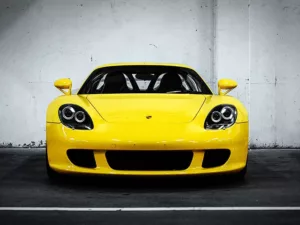 Cuadro Porsche Carrera GT supercar V10 con técnica de color selectivo, carrocería en color resaltada sobre fondo blanco y negro, fotografía artística del hypercar legendario de 612 CV edición limitada