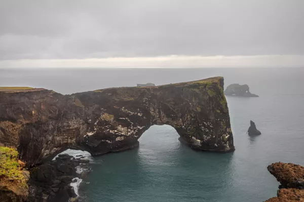 ARCHE-DE-DYRHOLAEY-COTE-SUD-ISLANDAISE-1 Arco de Dyrhólaey basalto negro océano Atlántico turquesa cielo dramático costa sur Islandia – fotografía fine art edición limitada