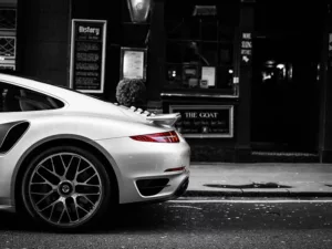 Porsche 991 Turbo rojo estacionado en calle londinense nocturna con arquitectura clásica británica, semáforo en rojo, fotografía artística urbana ambiente moody