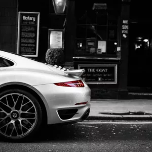 Porsche 991 Turbo rojo estacionado en calle londinense nocturna con arquitectura clásica británica, semáforo en rojo, fotografía artística urbana ambiente moody