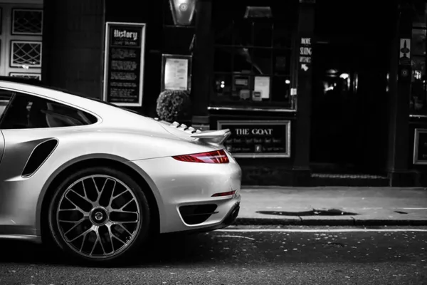 Porsche 991 Turbo rojo estacionado en calle londinense nocturna con arquitectura clásica británica, semáforo en rojo, fotografía artística urbana ambiente moody