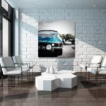 Imagen 2: Salón moderno con pared de ladrillo blanco, cuadro grande de Porsche 911 Type 901 azul colgado en el centro, sillones blancos, mesa baja geométrica blanca y lámpara de araña, decoración interior contemporánea