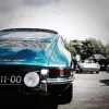 Old-Porsche-911-901-Duet-10-Prints Foto Porsche 911 Type 901 azul turquesa en primer plano mostrando la parte trasera del vehículo con inscripción "Porsche 911", faro redondo y otro Porsche classic blanco al fondo, fotografía artística Cars and Roses