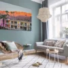 Fotografía enmarcada del hotel The Saguaro Palm Springs al atardecer exhibida en salón escandinavo moderno con pared verde salvia, sofá gris claro, silla de ratán yación bohemia decor