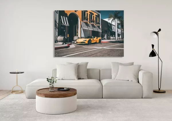 Salón moderno con cuadro grande de Ferrari F488 Spider amarilla colgado en la pared, sofá claro con cojines, mesa de café redonda y lámpara de pie, decoración contemporánea.