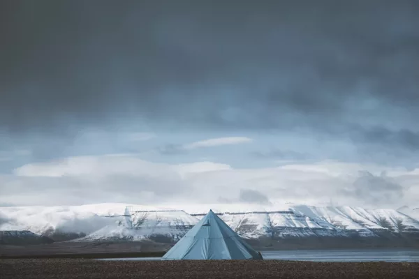 fotografia-svalbard-tienda-fiordo-artico Fotografía del Svalbard con tienda solitaria frente a los fiordos árticos nevados bajo un cielo dramático