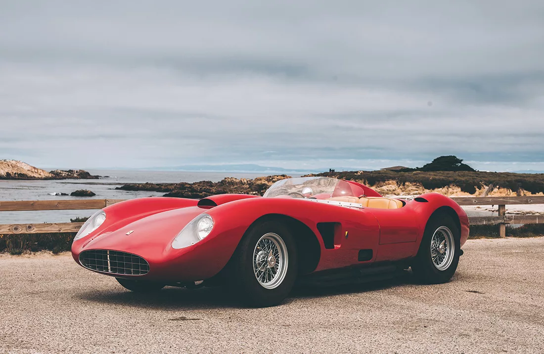 Fotografía artística de un cabriolet deportivo rojo vintage aparcado en una carretera junto al mar