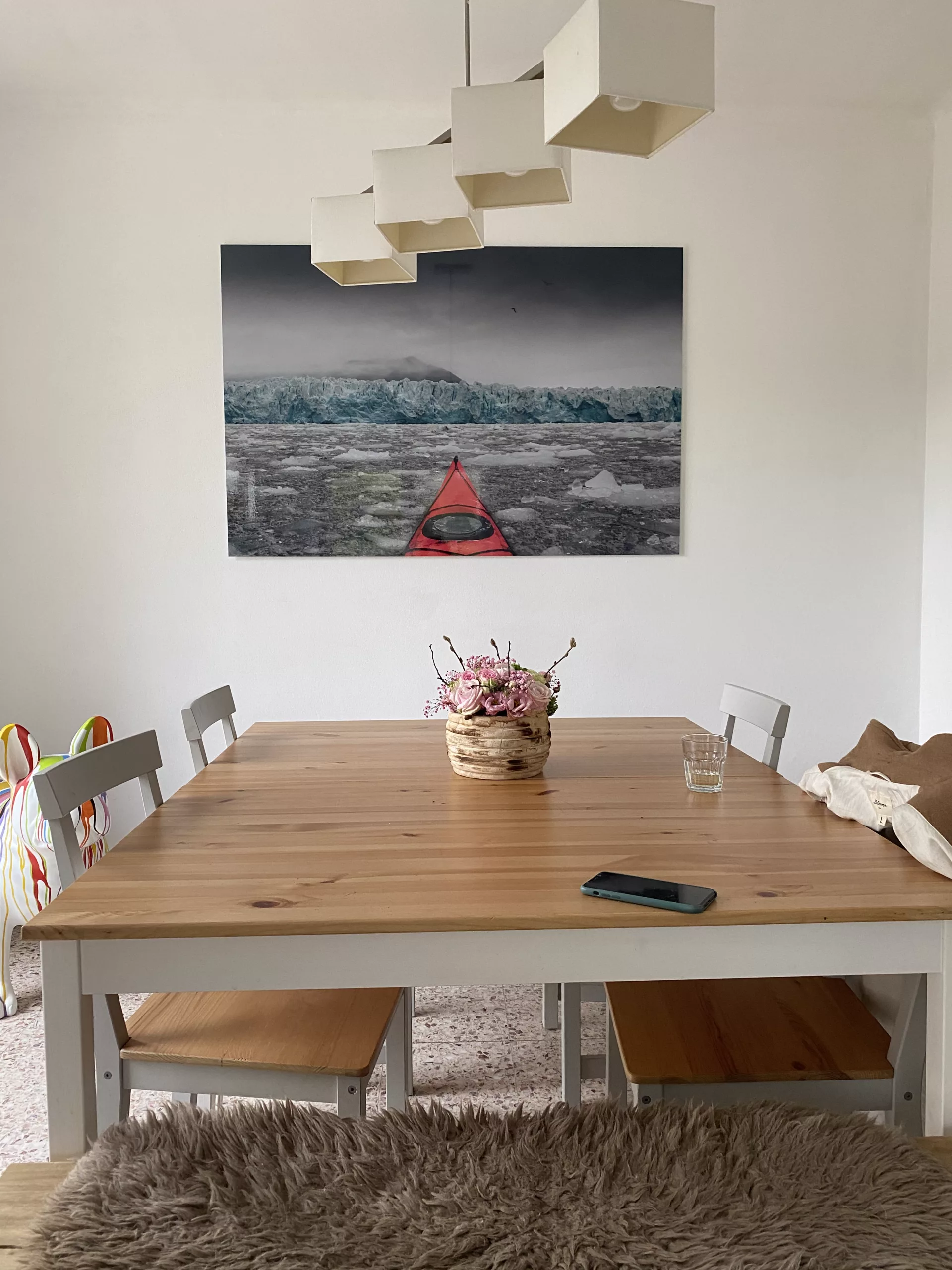 Cuadro fotográfico instalado sobre una mesa de comedor de madera, sillas negras — Cars and Roses