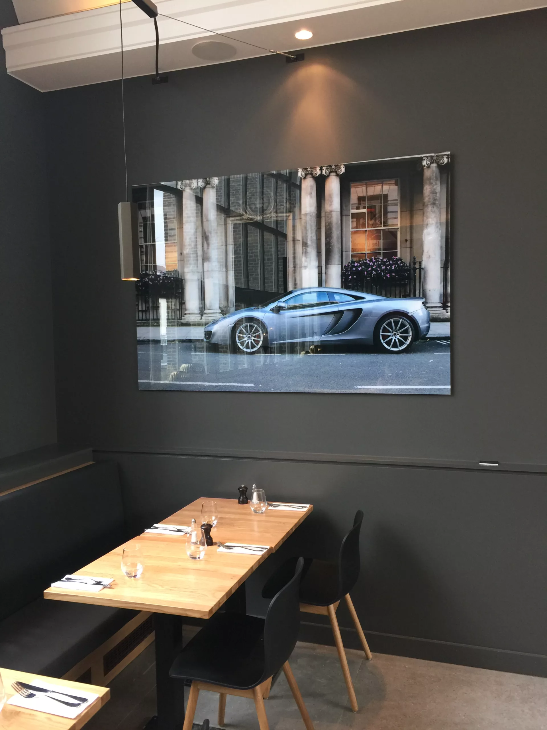 Showroom de coches con deportivo azul y cuadro fotográfico enmarcado sobre pared oscura — Cars and Roses