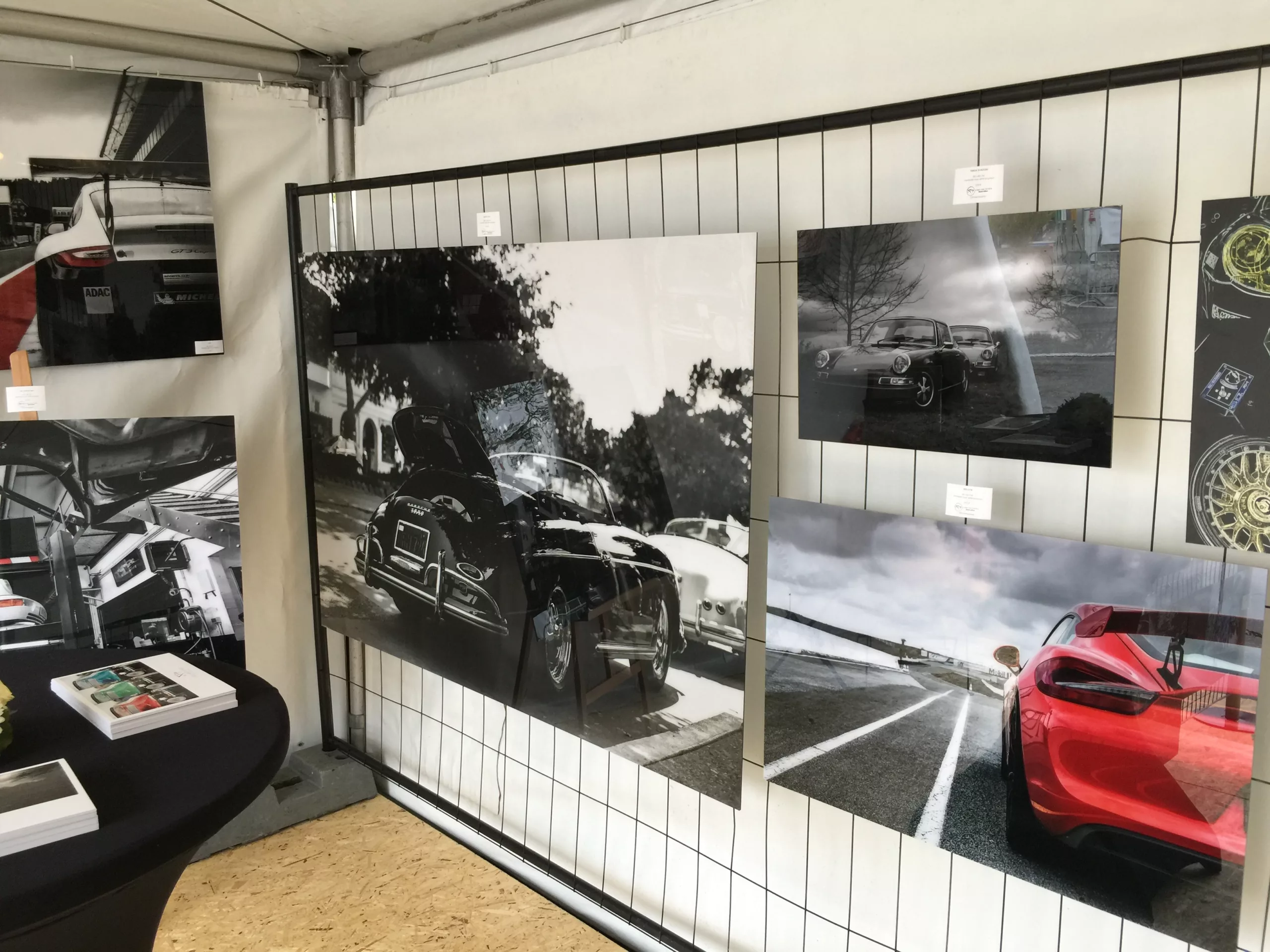 Pared con tres cuadros fotográficos de coches en blanco y negro en un espacio interior oscuro — Cars and Roses