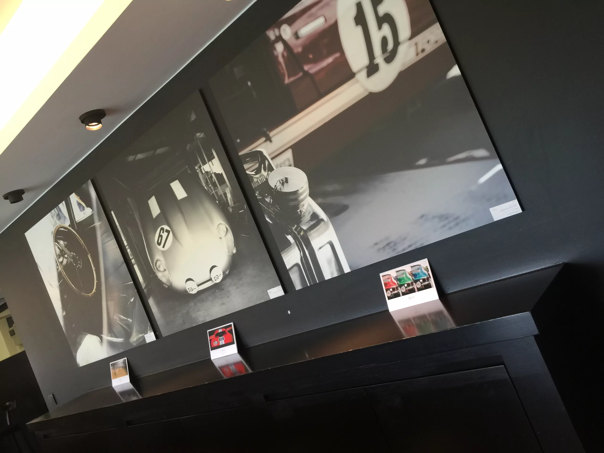 Dos cuadros fotográficos de coches en blanco y negro instalados en una habitación de luz tenue — Cars and Roses