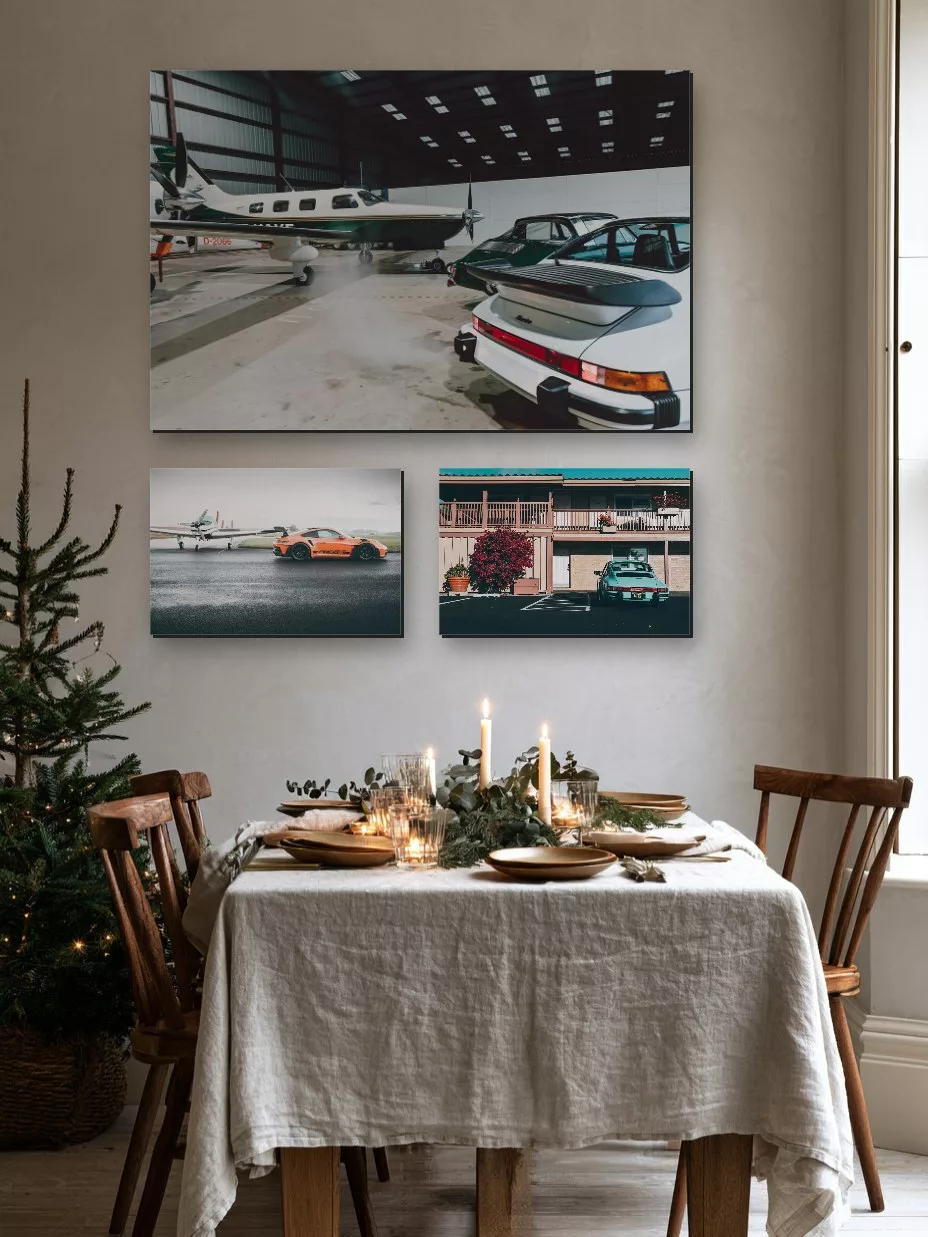 Tres fotografías de arte de Porsche sobre una mesa de Navidad