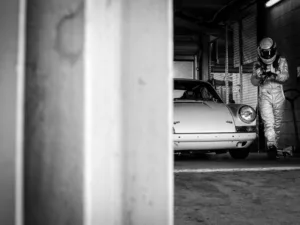 Porsche 911 y su piloto en el garaje de boxes — fotografía de autor en blanco y negro, edición limitada