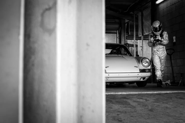 Porsche 911 y su piloto en el garaje de boxes — fotografía de autor en blanco y negro, edición limitada