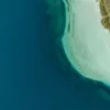 Fotografía aérea del lago Kournas en Creta: agua azul profundo, aguas turquesa poco profundas y una pequeña barca